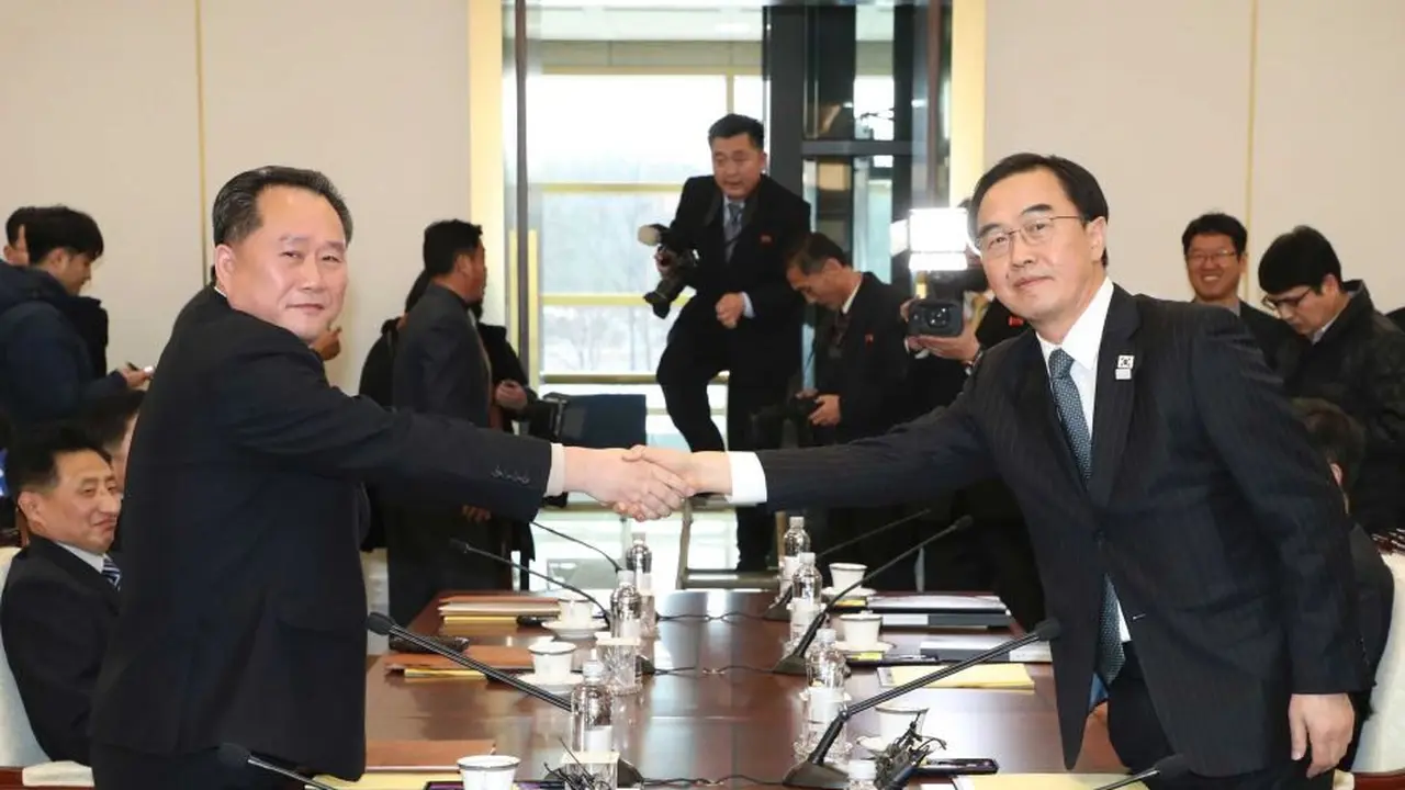 Menteri Unifikasi Korea Selatan, Cho Myoung-gyon berjabat tangan dengan mitra Korea Utara, Ri Son Gwon dalam pertemuan di desa gencatan senjata Panmunjom, Korea Selatan, 1 Juni 2018 (AP)