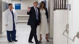 Presiden AS Donald Trump (tengah) saat mengunjungi rumah sakit Broward Health North Pompano Beach, Florida (16/2). Sebelumnya telah terjadi penembakan massal di sebuah sekolah di Florida yang menewaskan 17 orang. (AFP Photo/Jim Watson)