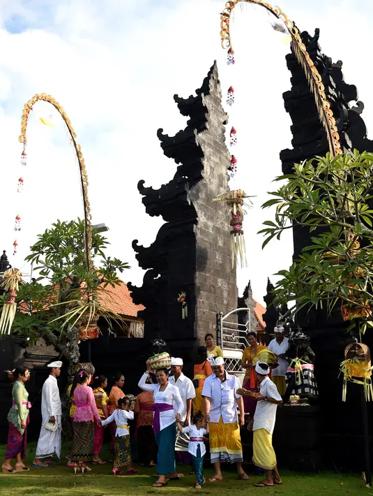 Umat Hindu menuju pura untuk sembahyang Hari Raya Galungan di Jimbaran, Bali, Rabu (5/4). Galungan dimaknai sebagai hari kemenangan Dharma (Kebaikan) melawan Adharma (Keburukan) yang dirayakan dengan persembahyangan di tiap Pura. (SONNY TUMBELAKA/AFP)