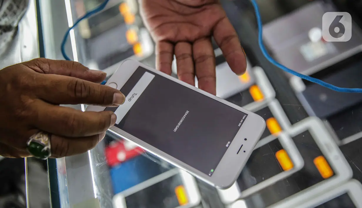 Petugas toko memeriksa IMEI handphone untuk didata di ITC Roxy Mas, Jakarta, Selasa (26/11/2019). Kemendag, Kemenperin, dan Kemenkominfo mulai memberlakukan aturan validasi IMEI pada 18 April 2020. (Liputan6.com/Faizal Fanani)