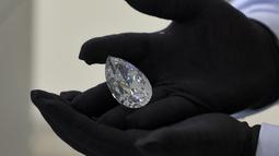 Seorang petugas rumah lelang Christie memperlihatkan sebuah berlian raksasa yang dijuluki "The Rock" kepada media di Dubai, Jumat (25/3/202). Rumah lelang Christie's menyatakan The Rock adalah berlian putih terbesar yang pernah dilelang. (Karim SAHIB/AFP)