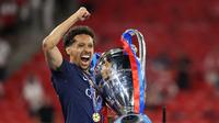 Marquinhos saat mengangkat trofi Liga Champions usai PSG mengalahkan Arsenal pada adu tendangan penalti. (Odd ANDERSEN / AFP)