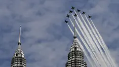 Tim Aerobatik angkatan udara Korea Selatan "Black Eagles" melintasi  menara kembar Petronas dalam Pameran Maritim dan Dirgantara Langkawi Internasional (LIMA) di Kuala Lumpur, Malaysia (29/3). (AFP Photo / Manan Vatsyayana)