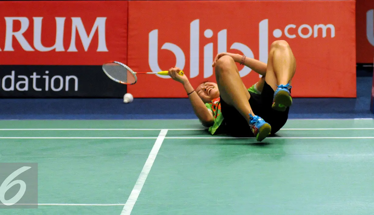 Pebulutangkis muda Indonesia dari klub Jaya Raya, Ruselli Hartawan terjatuh saat berusaha mengembalikan bola ke Li Xuerui (Tiongkok) di BCA Indonesia Open di Jakarta, Selasa (31/5). Ruselli kalah 21-16, 8-21. 11-21. (Liputan6.com/Helmi Fithriansyah)