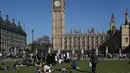 Sejumlah orang bersantai di bawah sinar matahari di Parliament Square di pusat kota London Inggris, Sabtu (8/4). (AFP PHOTO / Daniel Leal-Olivas)