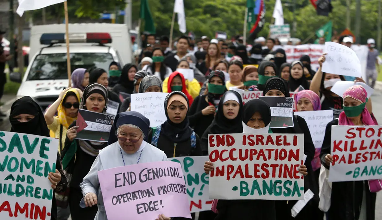 Seorang biarawati bersama kaum muslim Filipina melakukan aksi unjuk rasa menentang agresi militer Israel ke jalur Gaza, (15/7/2014). (REUTERS/Erik De Castro)