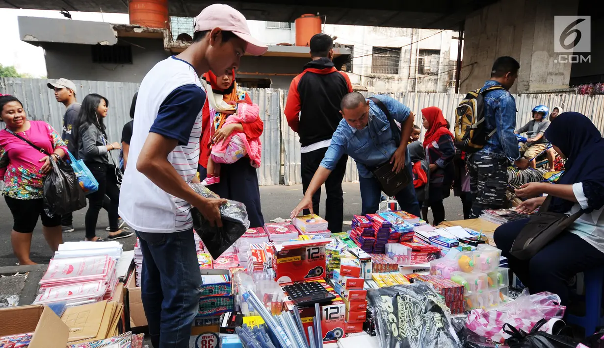Warga memilih peralatan sekolah yang dijajakan pedagang di sekitar Pasar Asemka, Jakarta, Rabu (5/7). Jelang bergantinya tahun ajaran baru, sejumlah warga berburu peralatan sekolah di kawasan Pasar Asemka Jakarta. (Liputan6.com/Helmi Fithriansyah)