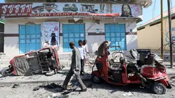 Sejumlah warga mengecek bajaj yang rusak parah usai terkena ledakan bom yang terjadi di Ibu Kota Mogadishu, Somalia (28/3). Hingga kini, belum ada pihak yang bertanggung jawab atas serangan ini. Namun, muncul dugaan kelompok militan berada di balik aksi tersebut. (Reuters/Feisal Omar)