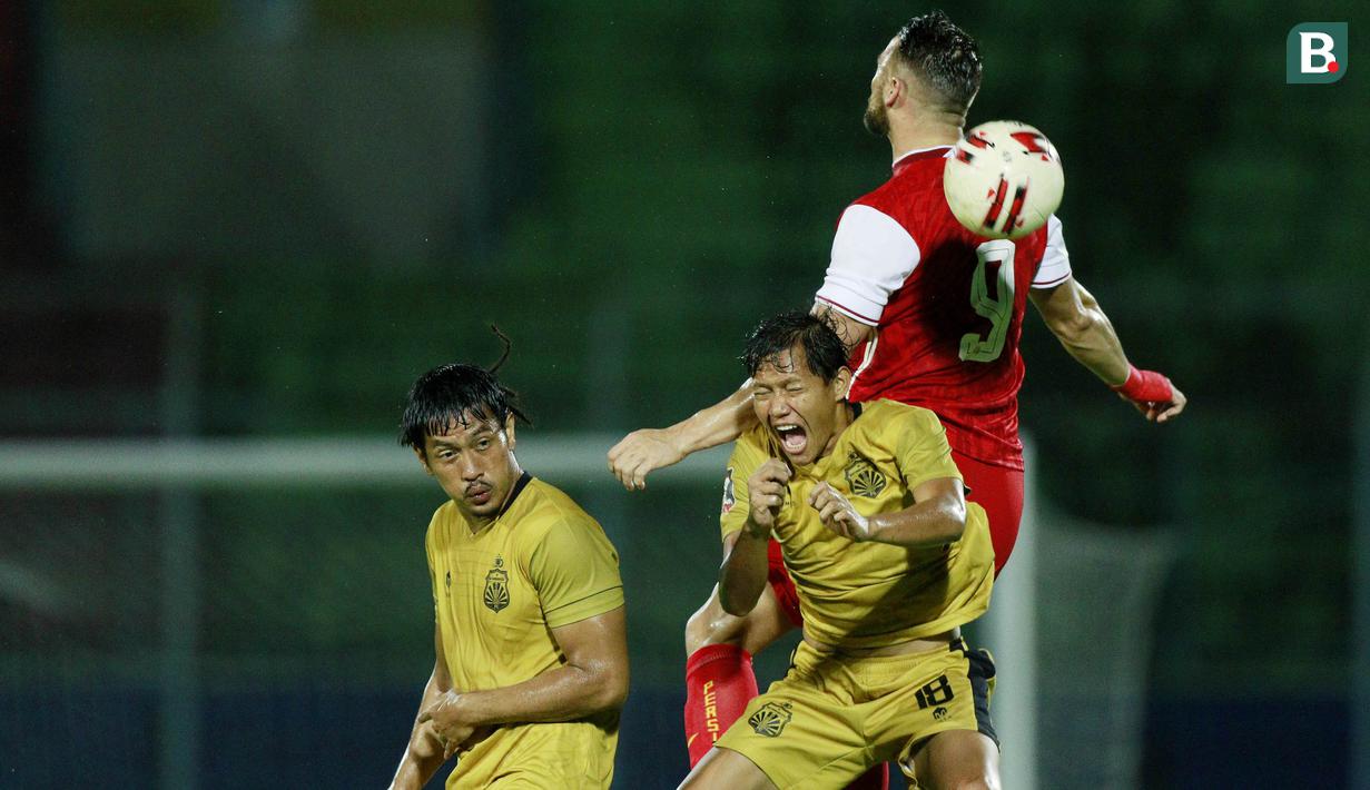 Gelandang Bhayangkara Solo FC, Adam Alis (kiri) berduel udara dengan striker Persija Jakarta, Marko Simic dalam laga matchday ke-3 Grup B Piala Menpora 2021 di Stadion Kanjuruhan, Malang, Rabu (31/3/2021). (Bola.com/M Iqbal Ichsan)