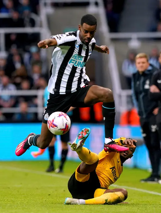 Pemain Newcastle United Alexander Isak berebut bola dengan pemain Wolverhampton Wanderers Nelson Semedo pada pertandingan sepak bola Liga Inggris di St. James' Park, Newcastle, Inggris, 12 Maret 2023. Newcastle United mengalahan Wolverhampton Wanderers dengan skor 2-1. (Owen Humphreys/PA via AP)