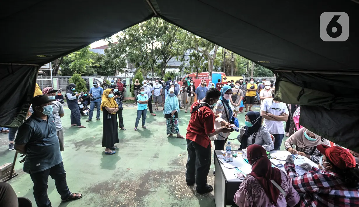 Warga antre mendaftar vaksin Covid-19 saat program Vaksinasi Keliling di RPTRA Pulo Besar, Sunter Jaya, Jakarta, Senin (12/7/2021). Pemprov DKI menggelar Vaksinasi Keliling dengan sistem jemput bola guna mempermudah pelayanan kepada masyarakat di area padat penduduk. (merdeka.com/Iqbal S Nugroho)