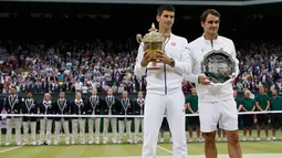 Juara Wimbledon 2015, Novak Djokovic dan Runner up, Roger Federer berpose bersama piala mereka usai final tunggal putra Wimbledon 2015, London, Minggu (12/7). Ini adalah gelar Wimbledon ketiga bagi Djokovic.  (REUTERS/Stefan Wermuth)