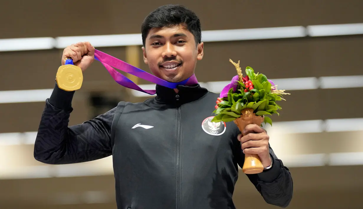 Peraih medali emas asal Indonesia, Muhammad Sejahtera Dwi Putra berpose saat upacara penghargaan olahraga menembak jarak sasaran lari 10 meter putra di Fuyang Yinhu Sports Center pada Asian Games ke-19 di Hangzhou, China, Senin (25/9/2023). (AP Photo/Aijaz Rahi)