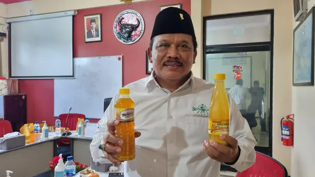 Plt Bupati Nganjuk Marhaen Djumadi membagikan minuman beras kencur pada acara  istigasah PDIP Jatim. (Dian Kurniawan/Liputan6.com)