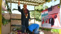 Bussa Krishna (33) melakukan penyembahan di depan patung Presiden AS Donald Trump di Desa Konney, Telangana, negara bagian India selatan (14/2/2020). Patung itu Bussa buat karena kekagumannya dengan sosok pemimpin Negeri Paman Sam tersebut. (AFP/Noah Seelam)