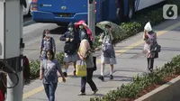 Pelajar beraktivitas menggunakan payung saat suhu udara mencapai 35 derajat Celcius di Kawasan Jalan MH Thamrin, Jakarta, Selasa (22/10/2019). (Liputan6.com/Helmi Fithriansyah)