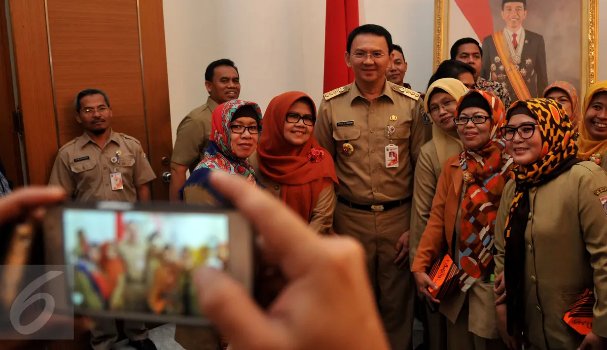 Pegawai Negeri Sipil (PNS) terihat foto bareng dengan Gubernur DKI Jakarta Basuki T Purnama di Balai Kota, Jakarta, Rabu (22/7/2015). Di sela - sela Halal Bihalal Mereka memanfaatkan momen untuk  ber-selfie bersama Gubernur. (Liputan6.com/JohanTallo)