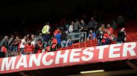 Para suporter Manchester United meninggalkan Stadion Old Trafford setelah laga kontra AFC Bournemouth ditunda pada Minggu (15/5/2016). (AFP/Oli Scarff)