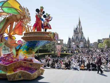 Karakter Disney Mickey dan Minnie Mouse (kiri atas) melambai saat parade siang hari baru di Urayasu, di pinggiran kota Tokyo pada 10 April 2023. (AFP/Richard A. Brooks)