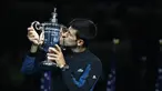 Petenis Serbia, Novak Djokovic mencium trofi turnamen AS Terbuka setelah mengalahkan Juan Martin del Potro dari Argentina pada partai final di New York, Minggu (9/9). Djokovic menang tiga set langsung 6-3, 7-6 (4), 6-3. (MATTHEW STOCKMAN/GETTY IMAGES/AFP)