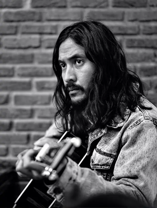 Ekspresi Marcello Tahitoe alias Ello saat bermain gitar dengan rambut gondrong dan berewoknya. Debut albumnya yang berjudul namanya sendiri dirilis pada 28 Februari 2005 dan masuk dalam deretan album terlaris. (Instagram/@marcello_tahitoe)