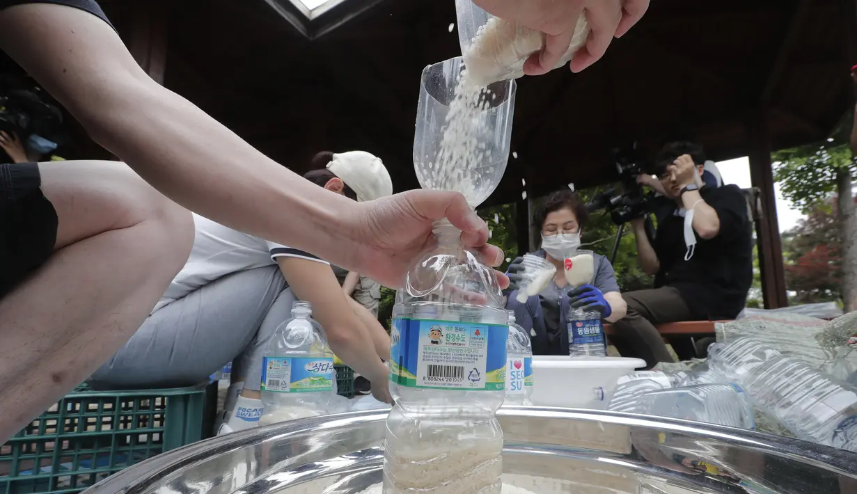 Para pembelot Korea Utara mengisi botol-botol plastik dengan beras dan masker untuk dikirim ke Korea Utara dengan balon, Seoul, Korea Selatan, Kamis (18/6/2020). Tindakan pembelot selama ini mengirimkan benda-benda propaganda anti-Pyongyang telah membuat Korea Utara murka. (AP Photo/Ahn Young-joon)