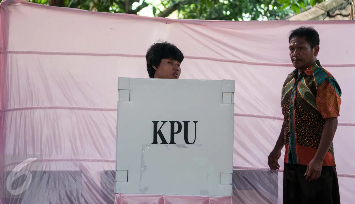 Seorang pria penyandang disabilitas menyobols dibilik suara saat menggunakan hak pilihya dalam Pilkada Putaran kedua di TPS 07 Kelurahan Cawang, Jakarta, Rabu (19/4). (Liputan6.com/Gempur M. Surya)