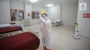 Petugas mengenakan hazmat saat menyiapkan tempat tidur di Tower 8 Wisma Atlet Pademangan, Jakarta, Selasa (15/6/2021). Koordinator Lapangan RSDC Wisma Atlet Letkol Marinir M. Arifin mengatakan soal alternatif Tower 8 Wisma Atlet Pademangan untuk pasien OTG COVID-19. (Liputan6.com/Faizal Fanani)