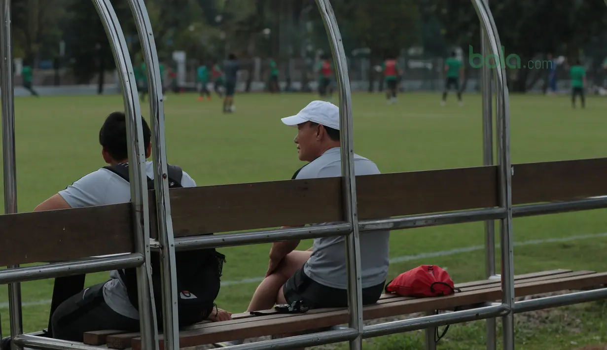 Pelatih Korea Selatan U-23, Kim Hak-bum (kanan) santai menonton sesi latihan timnas Indonesia U-23 di Lapangan ABC Senayan, Jakarta (20/6/2018). Indonesia akan melawan Korea pada laga uji coba 23-6-2018. (Bola.com/Nick Hanoatubun)