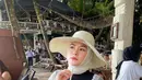 Begini gaya santai Yunita Lestari saat duduk di tepian pantai sambil menikmati minuman. Penampilannya semakin kece dengan mengenakan topi bundar. (FOTO: instagram.com/lee_yunita/)