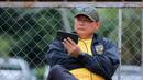 Manajer Timnas Indonesia U-22, Sumardji, tampak serius menyaksikan laga Timnas Vietnam U-22 vs Timnas Malaysia U-22 dari layar handphone. (Bola.com/Bagaskara Lazuardi)