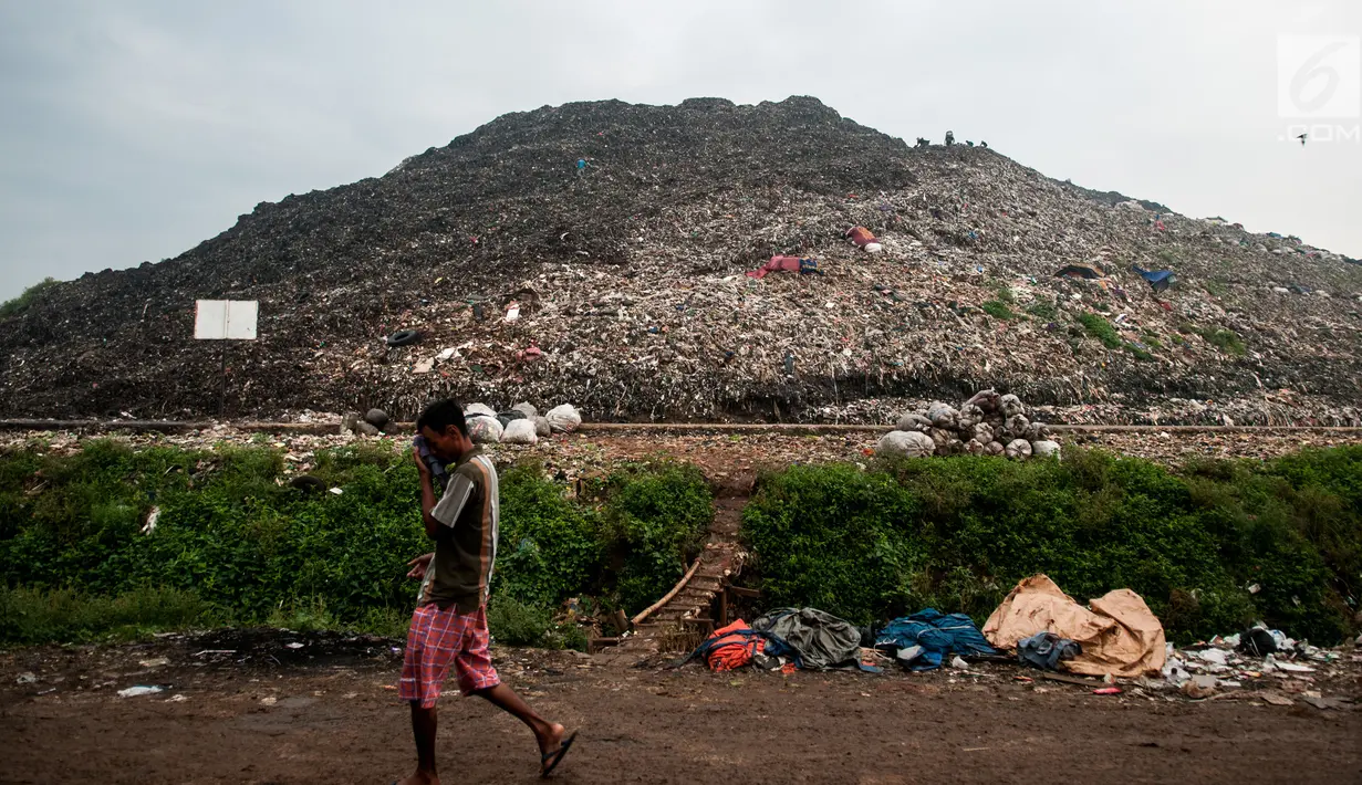 Seorang warga melintas di depan tumpukan sampah di TPA Bantar Gebang, Kota Bekasi, Jawa Barat.  (Liputan6.com/Yoppy Renato)