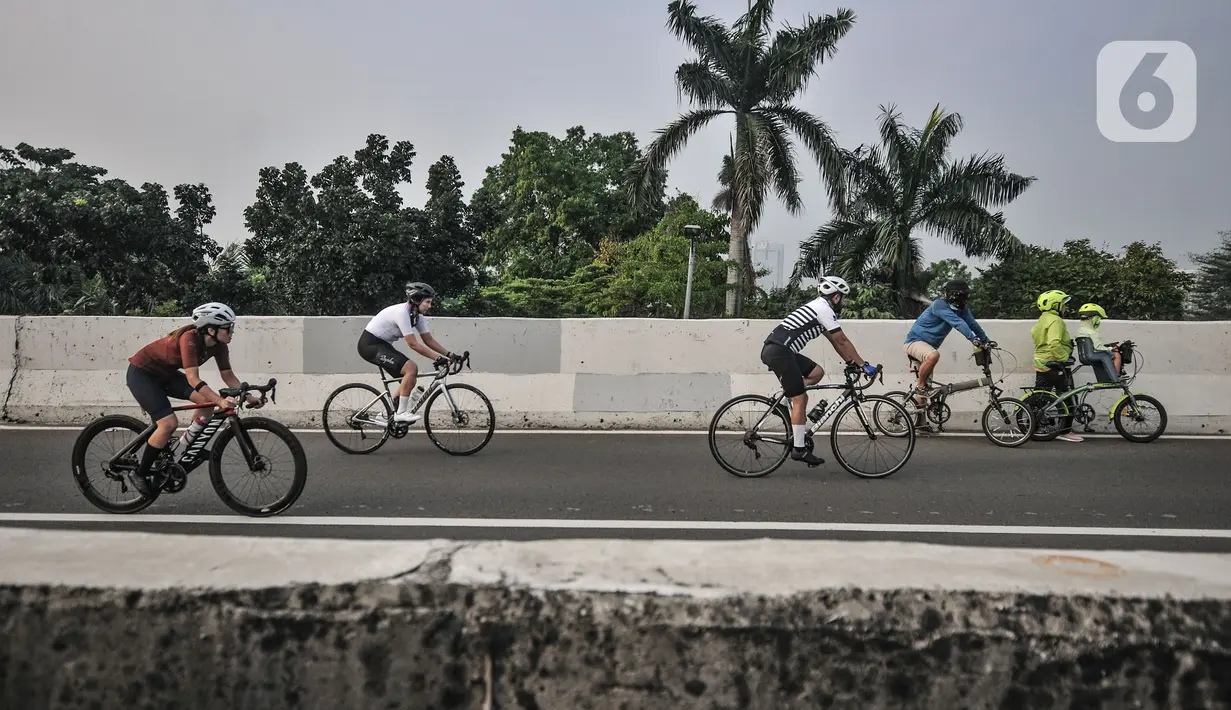 Pesepeda melintasi Jalan Layang Non Tol (JLNT) Kampung Melayu-Tanah Abang saat uji coba jalur sepeda balap atau Road Bike, Jakarta, Minggu (23/5/2021). Pemprov DKI melakukan uji coba lintasan Road Bike di JLNT Kampung Melayu-Tanah Abang mulai pukul 05.00 WIB-08.00 WIB. (merdeka.com/Iqbal S Nugroho)