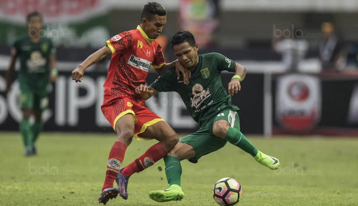 Gelandang Persebaya, Oktafianus Fernando, berusaha melewati gelandang Martapura FC, Agus Wibowo, pada laga semifinal Liga 2 2017 di Stadion GBLA, Bandung, Sabtu (25/11/2017). Persebaya menang 3-1 atas Martapura FC. (Bola.com/Vitalis Yogi Trisna)