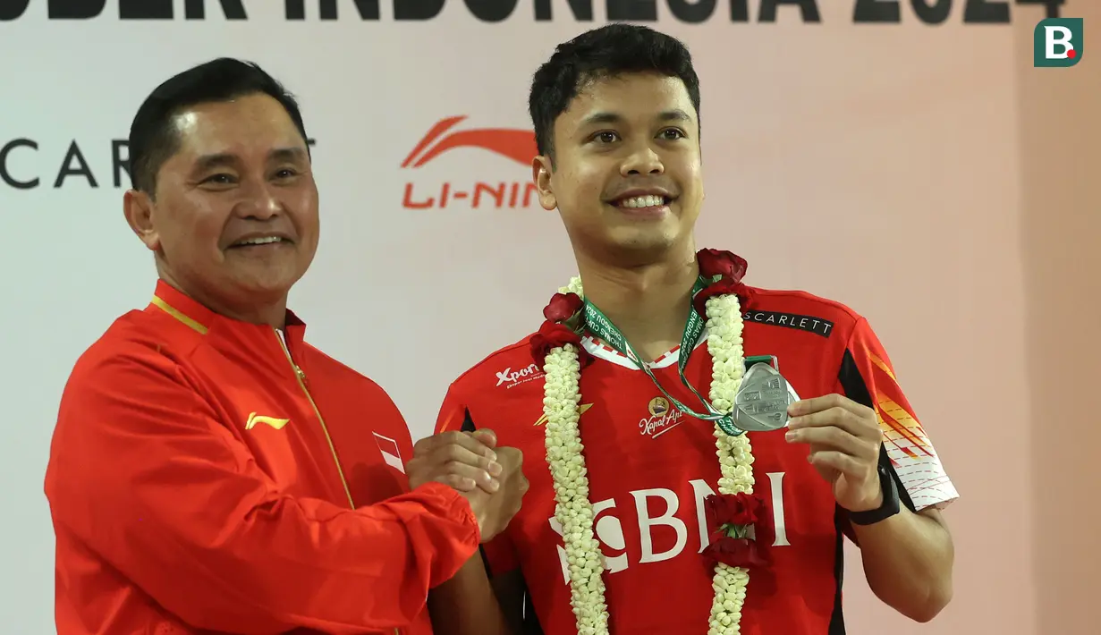 <p>Pebulu tangkis Indonesia, Anthony Sinisuka Ginting (kanan) memperlihatkan medali runner up Thomas Cup 2023 saat berfoto bersama dengan Sekjen PP PBSI, Fadil Imran di Gedung VVIP Terminal 3 Bandara Soekarno Hatta, Tangerang, Banten, Senin (06/05/2024). (Bola.com/M Iqbal Ichsan)</p>