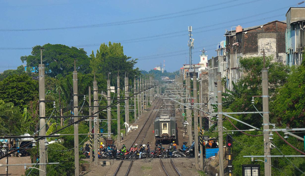 Kendaraan roda dua maupun roda empat masih dapat melintas secara bergantian tanpa hambatan berarti. Tampak dalam foto, situasi arus lalu lintas saat proses pemasangan palang pintu di perlintasan sebidang Jalan Ampera, dekat Stasiun Bekasi Timur, Bekasi, Jawa Barat. (Kapanlagi.com/Budy Santoso)