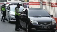 Polisi memberikan surat tilang kepada pengemudi mobil berpelat nomor genap di Jalan MT Haryono, Jakarta, Rabu (1/8). Polisi hari ini mulai memberlakukan sanksi tilang kepada pelanggar aturan di kawasan perluasan ganjil genap (Merdeka.com/Iqbal S. Nugroho)