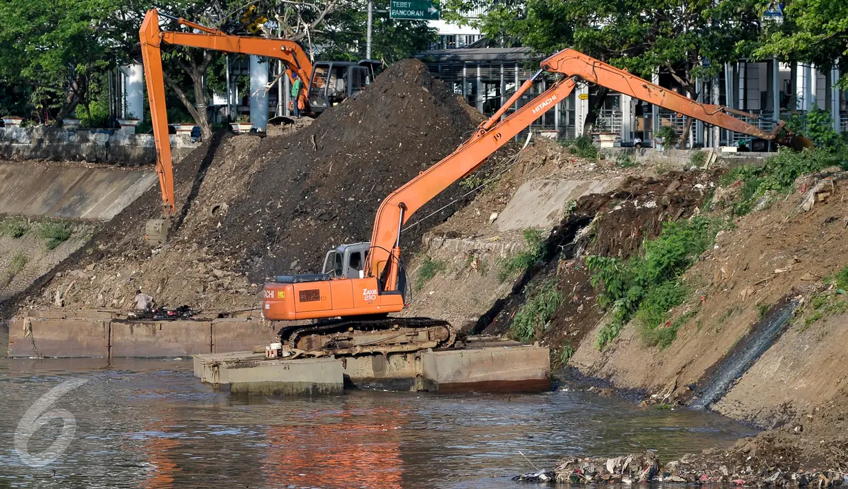 Dua alat berat melakukan pengerukan tumpukan sisa lumpur dan tanah yang menumpuk di pinggir kali Ciliwung, Jakarta, Kamis (28/7). Dinas Tata Air DKI Jakarta bersihkan tumpukan tanah dan lumpur sisa pengerukan kali Ciliwung. (Liputan6.com/Yoppy Renato)