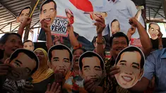 Sejumlah pedagang dan pengunjung mengenakan topeng bergambar Jokowi di Pasar Gede, Solo, (20/10/14). (ANTARA FOTO/Maulana Surya)