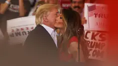 Presiden AS, Donald Trump mencium istrinya, Melania Trump selama reli kampanye di Bandara Internasional Orlando Melbourne, Florida (18/2). Donald Trump terlihat mesra dengan sang istri saat pertemuan tersebut. (Joe Raedle / Getty Images / AFP)