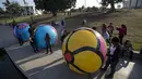 Sejumlah relawan mempersiapkan bola raksasa untuk ikut dalam pameran "Spheres" di Los Angeles, California, AS (21/8/2015). Acara ini menampilkan sekitar 3.000 bola raksasa yang dihias oleh para relawan. (REUTERS/Mario Anzuoni)