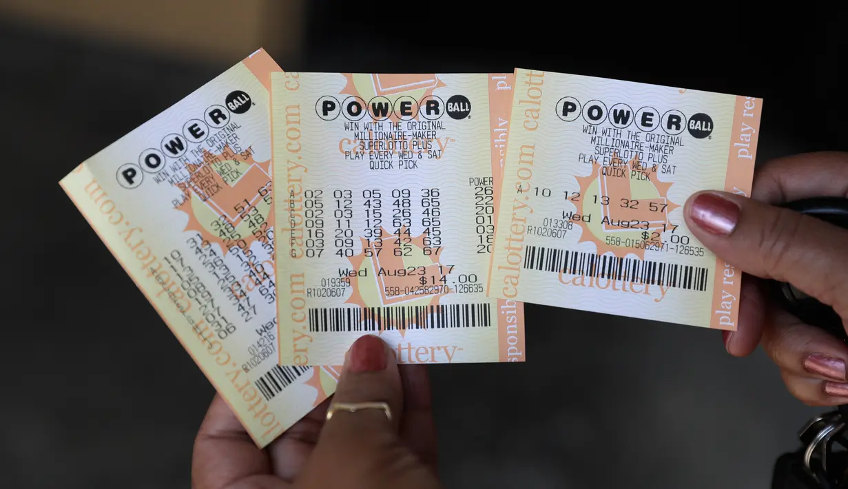 Seorang pelanggan menunjukan tiket lotre Powerball di Fremont, Calif, AS (23/8). (AP Photo/Marcio Jose Sanchez)