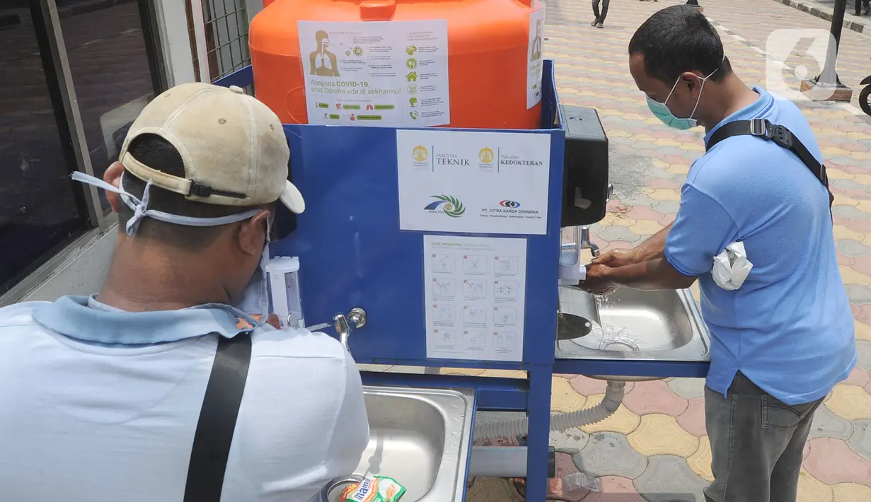 Warga menggunakan fasilitas tempat cuci tangan atau wastafel portabel di Pasar Bogor, Jalan Suryakencana, Kota Bogor, Sabtu (29/3/2020). Wastafel portabel itu sebagai upaya meningkatkan perilaku hidup bersih dan sehat (PHBS) juga mencegah penyebaran pandemi virus Corona. (merdeka.com/Arie Basuki)