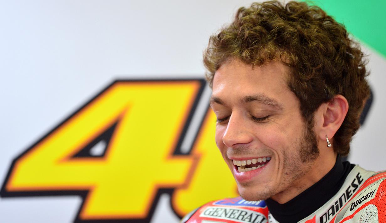 Pebalap MotoGP asal Italia, Valentino Rossi, tertawa saat jeda usai sesi latihan di Sirkuit Misano, San Marino, Kamis (15/9/2012). (AFP/Gabriel Bouys)
