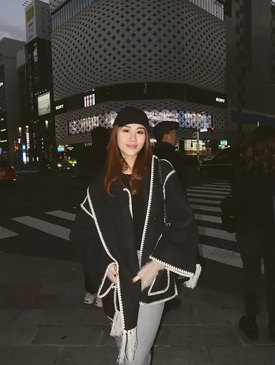 Kali ini, ia tampil dengan coat wool pendek berwarna hitam dengan detail list putih yang memberikan sentuhan klasik. Coat tersebut dipadukan dengan selendang dan topi berwarna senada untuk kesan yang serasi. Sebagai bawahan, ia memilih celana jeans yang menambah nuansa kasual namun tetap stylish. [@aaliyah.massaid].