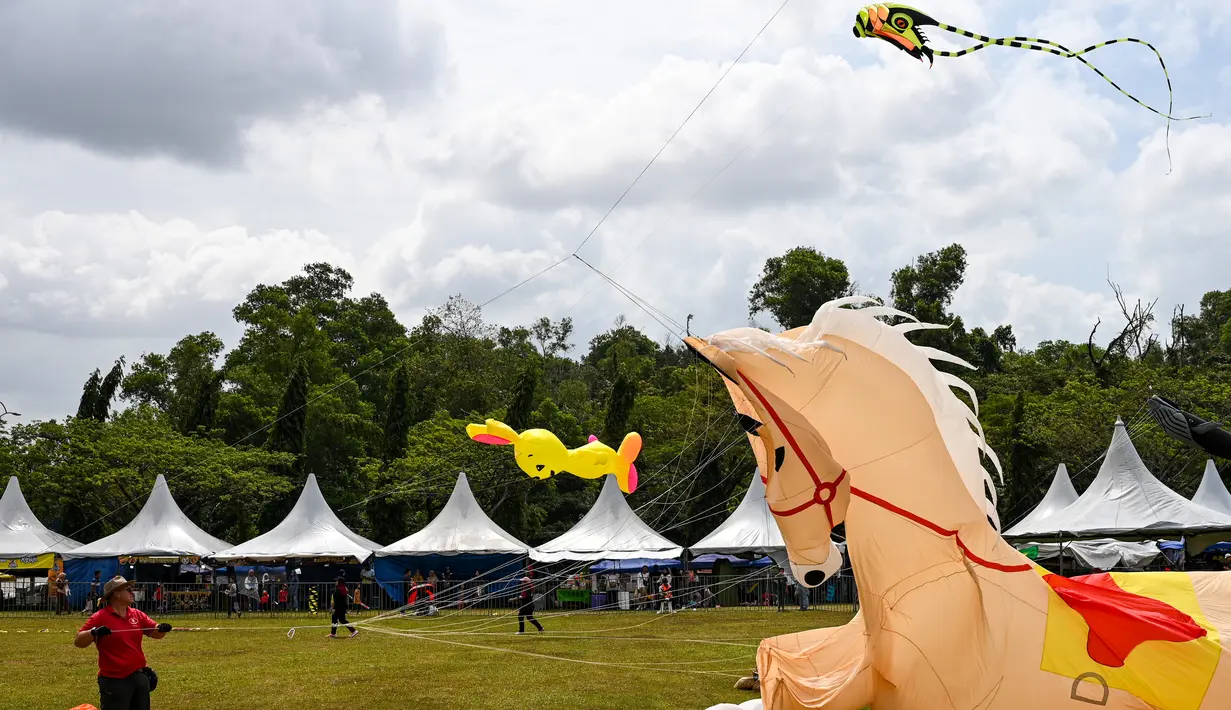 Para peserta menerbangkan layang-layang mereka selama Festival Layang-Layang Dunia Pasir Gudang ke-25 di Bukit Layang-Layang di negara bagian Johor, Malaysia, pada 24 Februari 2023. - Festival ini dilanjutkan kembali setelah 3 tahun terhenti karena pandemi Covid-19. (AFP/Roslan Rahman)
