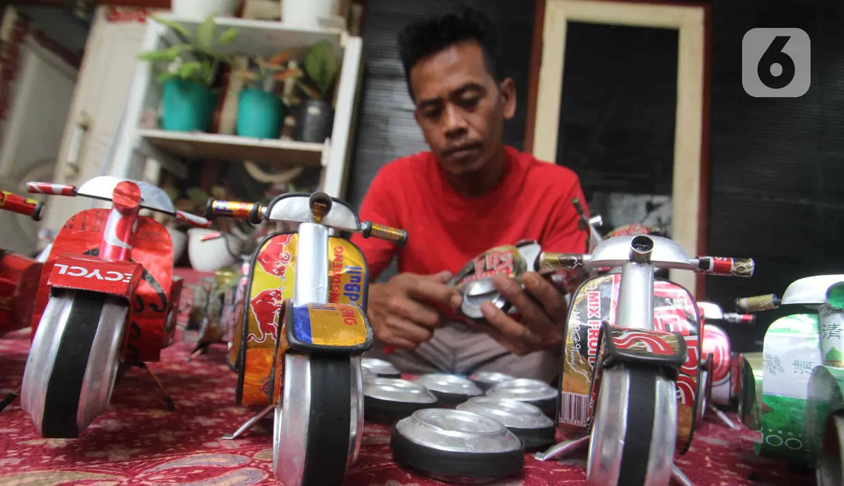 Perajin Ogifson Harianja, menyelesaikan miniatur vespa dari kaleng bekas, Jakarta, Jumat (7/1/2022). Pemerintah melalui Kemenko Perekonomian telah mengumumkan bahwa plafon penyaluran KUR 2022 ditingkatkan menjadi Rp373,17 triliun, dengan suku bunga tetap sebesar 6 persen. (Liputan6.com/Angga Yuniar)