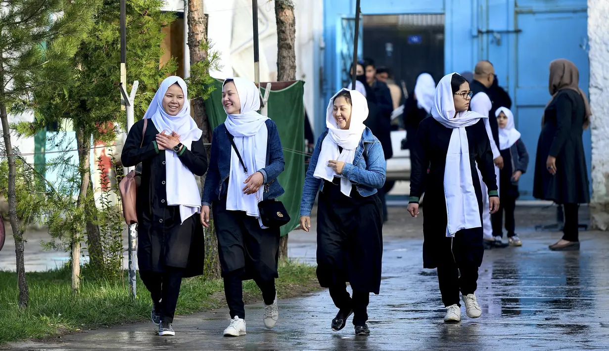 Anak perempuan tiba setelah sekolah mereka dibuka kembali di Kabul, Rabu (23/3/2022). Pembukaan kembali sekolah menengah untuk anak perempuan di seluruh Afghanistan memicu kegembiraan dan ketakutan puluhan ribu siswa yang kehilangan pendidikan sejak Taliban kembali berkuasa. (Ahmad SAHEL ARMAN/AFP)