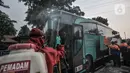 Petugas pemadam kebakaran menyemprotkan disinfektan kepada penumpang bus AKAP di Terminal Kampung Rambutan, Jakarta, Minggu (23/5/2021). Penyemprotan rutin dilakukan kepada bus AKAP dan penumpang selama arus mudik Lebaran sebagai langkah mencegah penyebaran Covid-19. (merdeka.com/Iqbal S Nugroho)