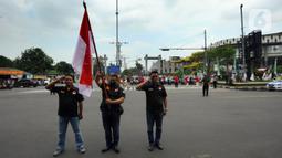 Warga bersama pengguna jalan melakukan penghormatan saat detik-detik proklamasi 17 Agustus di ruas jalan protokol Jakarta-Bogor, pertigaan Cibinong, Bogor, Jawa Barat, Rabu (17/8/2022). Sejumlah pengguna jalan terlihat turun dari kendaraannya dan melakukan sikap hormat. (merdeka.com/Arie Basuki)